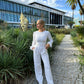 beautiful blond woman in white jumpsuit in palm trees in Portugal
