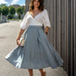 beautiful lady enjoying a sunny day outside, wearing a white blouse and blue wool skirt, below-the-knee length