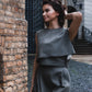 beautiful woman brunette on the streets of riga in a gray classic three piece dress
