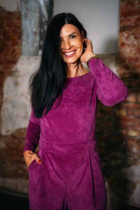 beautiful black haired woman in a magenta jumpsuit