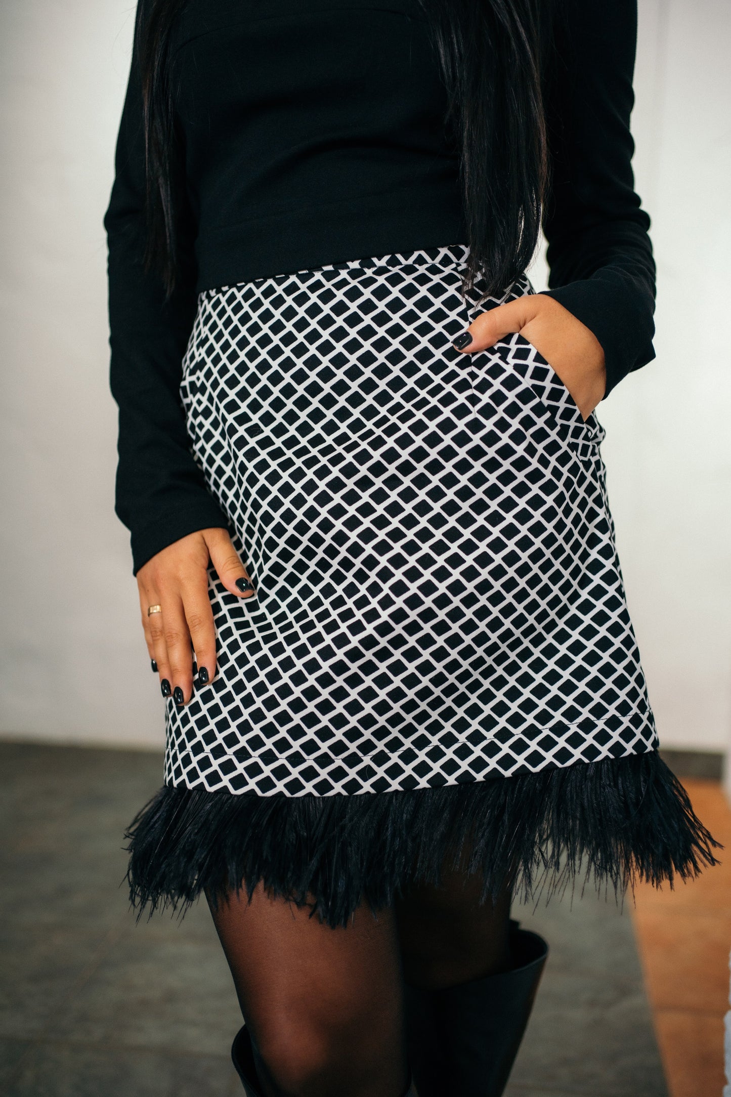 Black and white two-piece dress set of a long-sleeved top and feather skirt with pockets