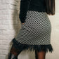 Black and white two-piece dress set of a long-sleeved top and feather skirt with pockets