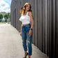 beautiful lady in a sunny weather, white ruffled top, jeans and black heels