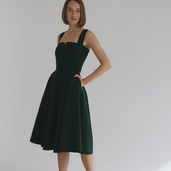 graceful woman in a two-piece dress set, that consists of a corset top and a long flowy skirt, everything in emerald green color