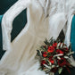 lace wedding dress on a sofa with rose bouquet