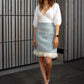 beautiful lady in a white blouse and blue wool mini skirt with feathers
