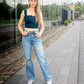 emerald green corset top paired with jeans and white sneakers