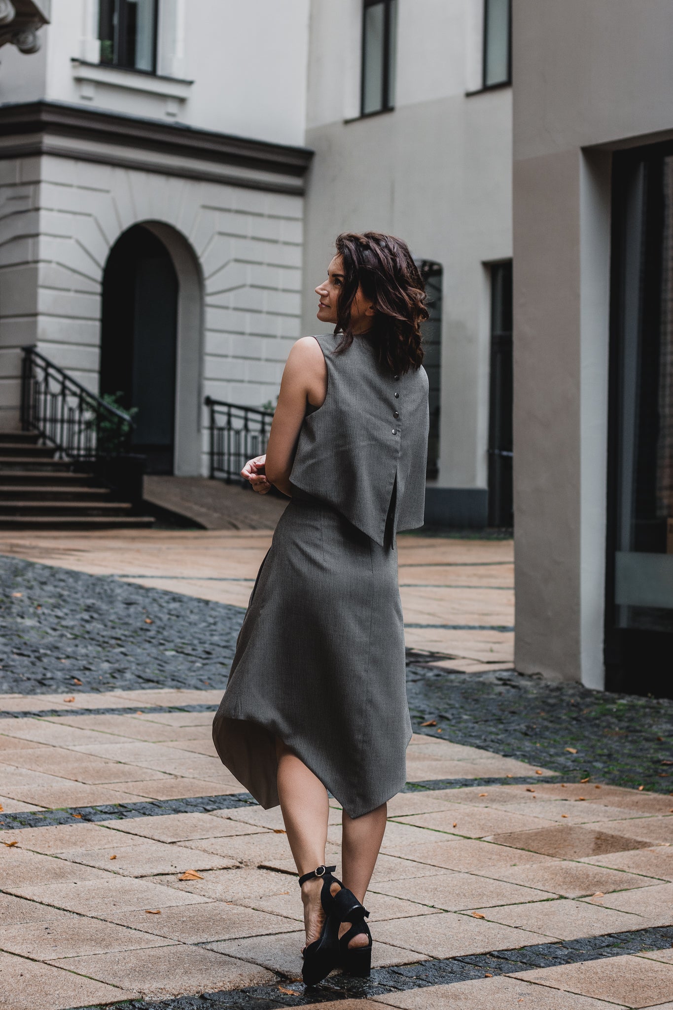 beautiful woman on a sunny day, wearing three piece dress -  two tops and gray brown triangle skirt together with black heels
