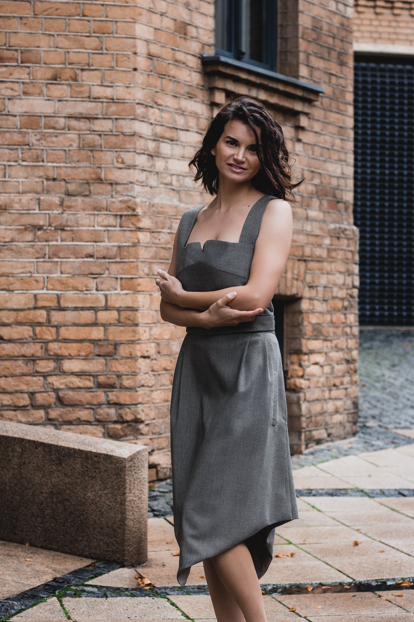 beautiful brunette on the streets in a gray two piece office dress - a corset top and a triangle skirt