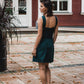 beautiful brunette on the streets walk in an emerald green two-piece mini dress, that consists of a corset top and a mini skirt, paired with black heels. this picture is made from the back, the woman has a dreamy look.