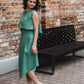 beautiful woman in mint green three-piece dress set smiling over the shoulder