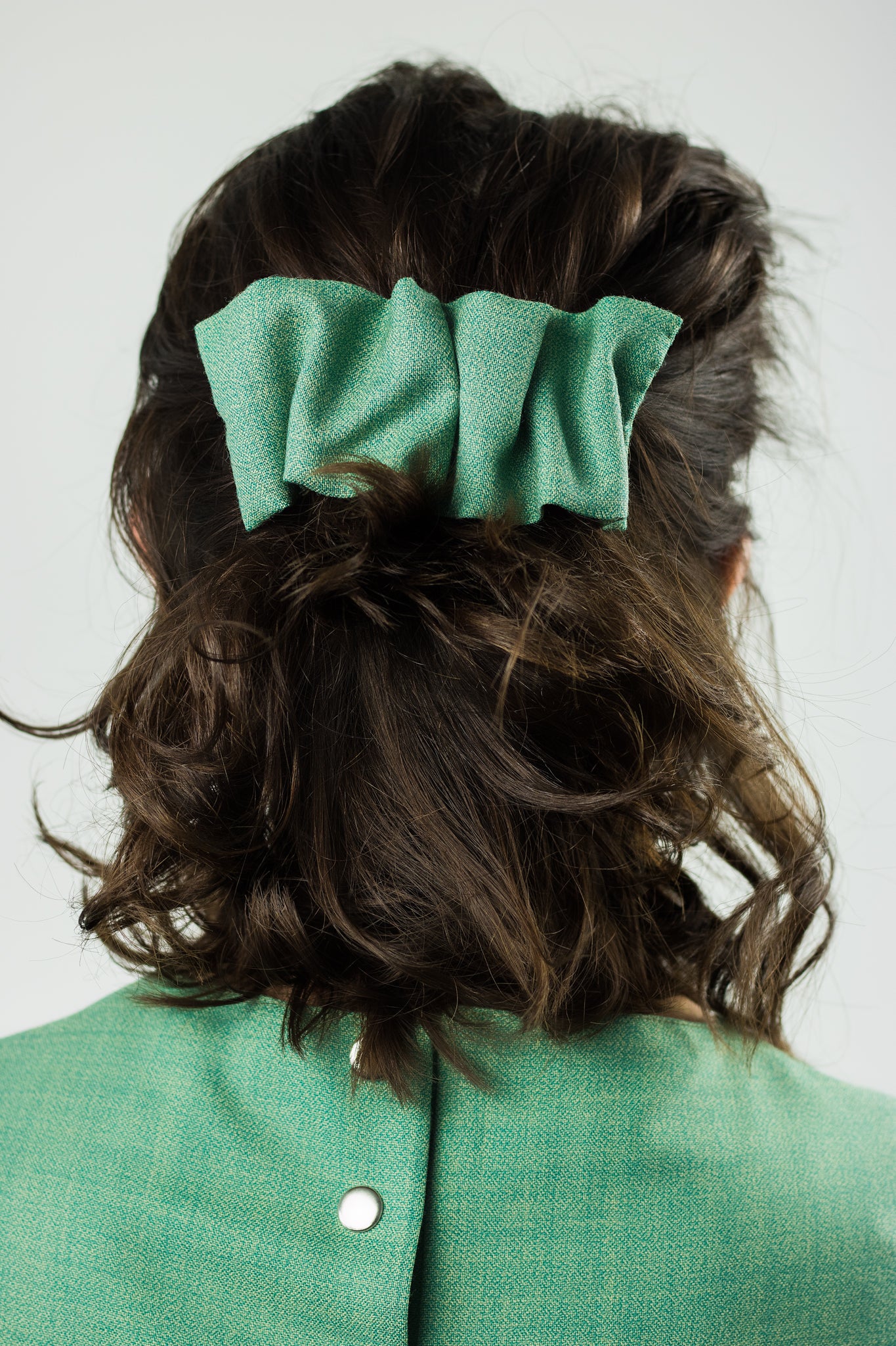 mint green hair clip pinned in the hair